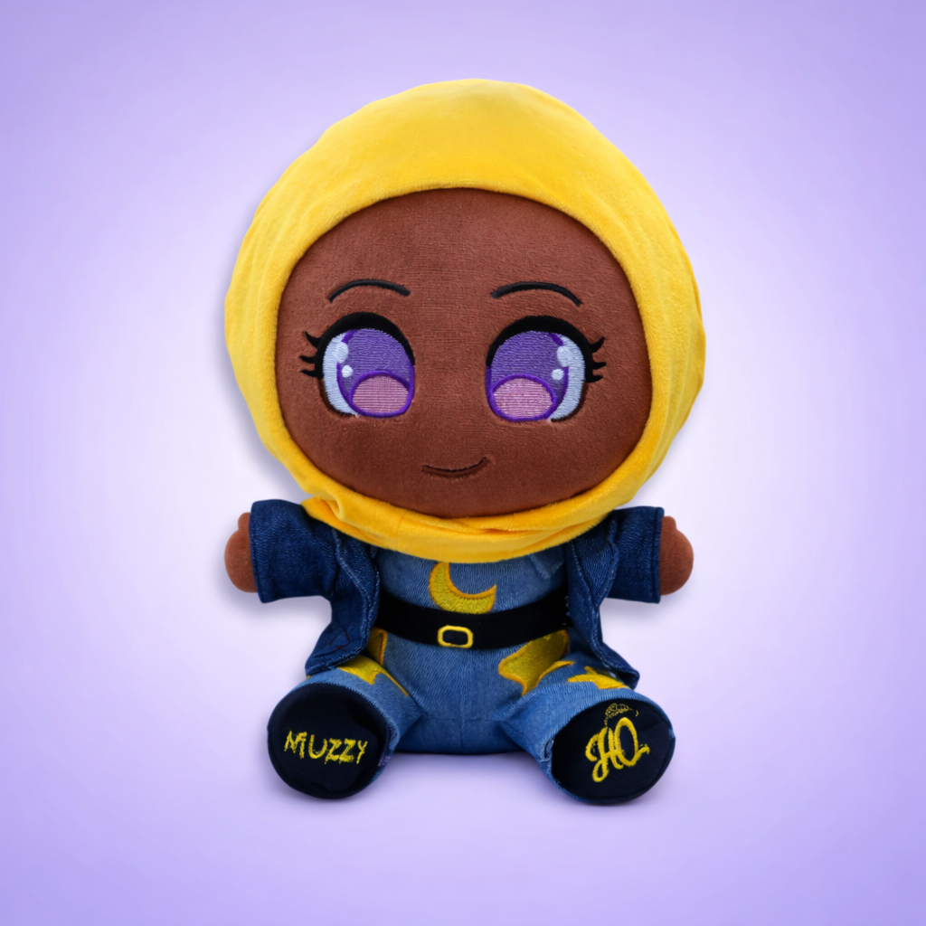 Cute plush doll wearing a purple hijab and colorful outfit, smiling with big eyes.