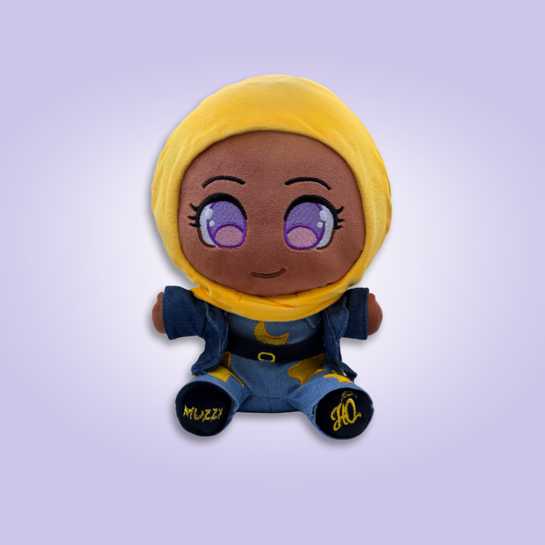 Cute plush doll wearing a purple hijab and colorful outfit, smiling with big eyes.